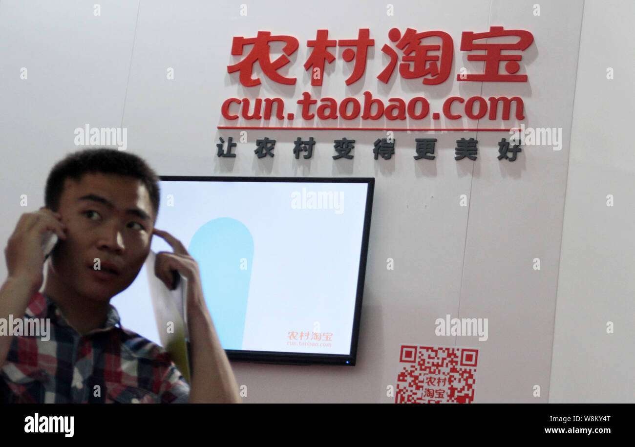 --FILE--A visitor walks past the stand of cun.taobao.com, Chinese e-commerce Alibaba's shopping service for rural areas, during an exhibition in Beiji Stock Photo
