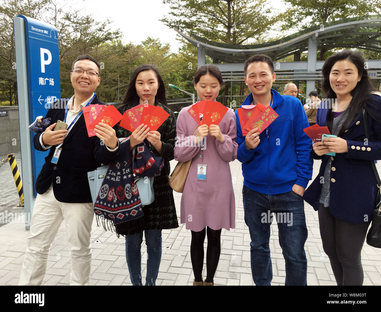 Employees of Chinese Internet giant Tencent show the hongbao (red envelopes with lucky money) they got from senior executives at the headquarters of T Stock Photo