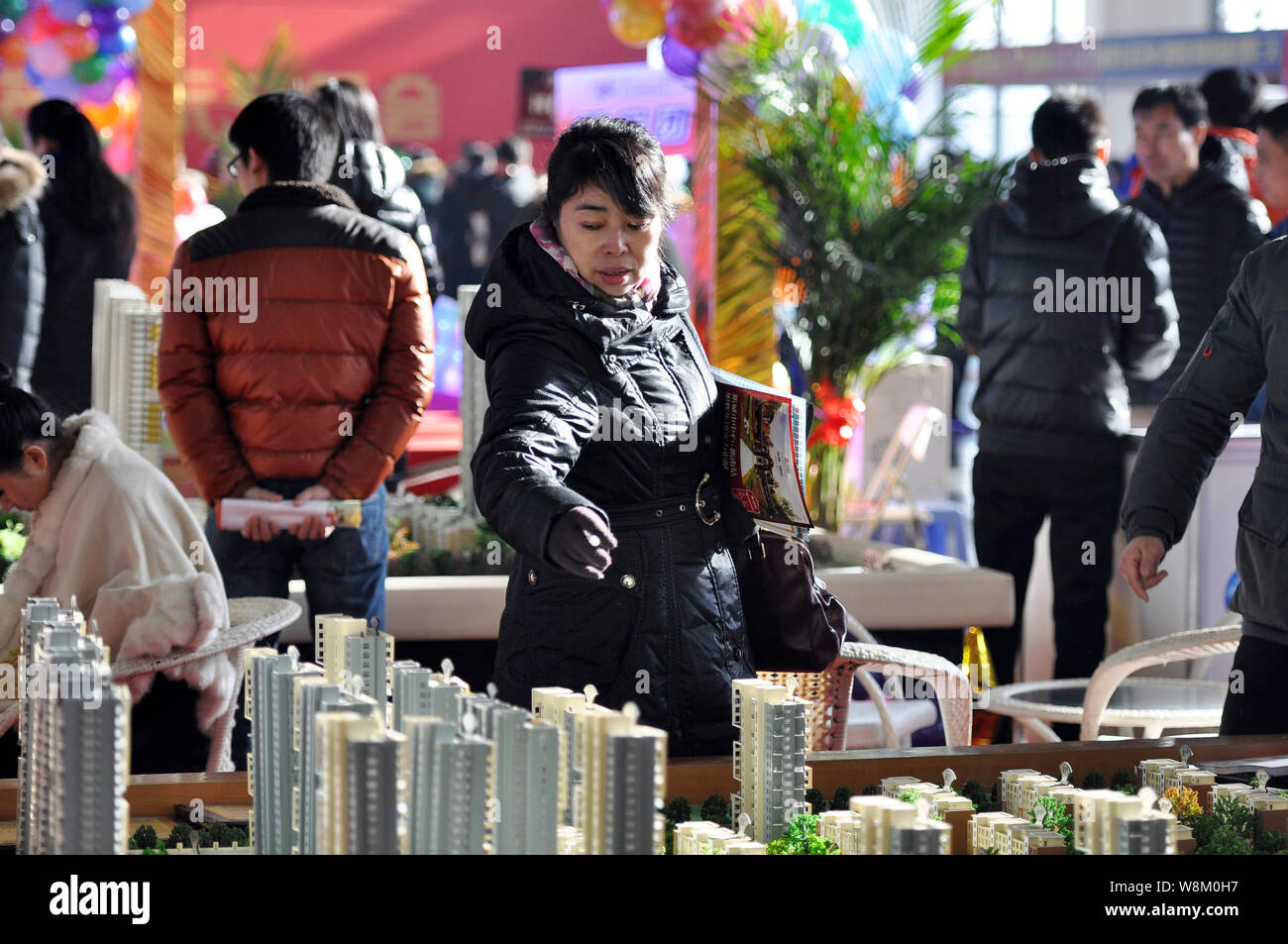 --FILE--Chinese homebuyers look at housing models of residential property projects during a real estate fair in Shenyang city, northeast China's Liaon Stock Photo