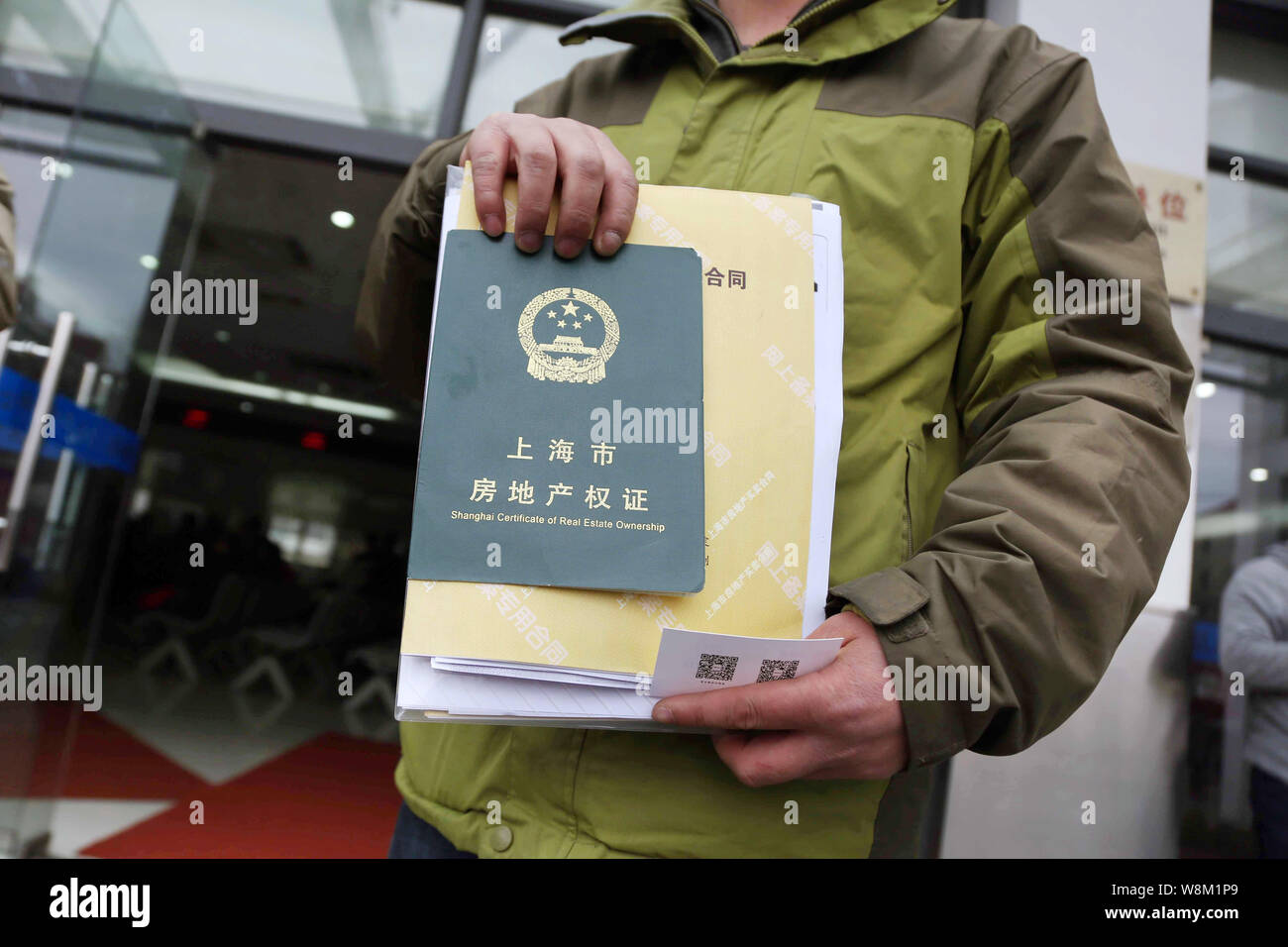 A Chinese homeowner shows his real estate ownership certificate and