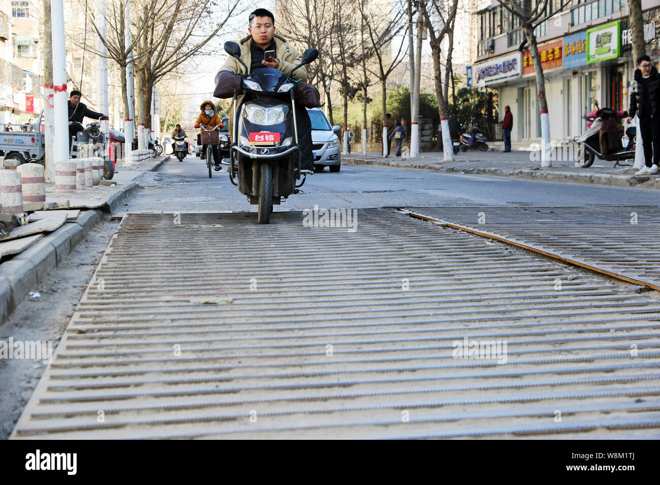 Steel Plate Riding A cyclist rides on steel plates with rebar on a road in Zhengzhou city ...