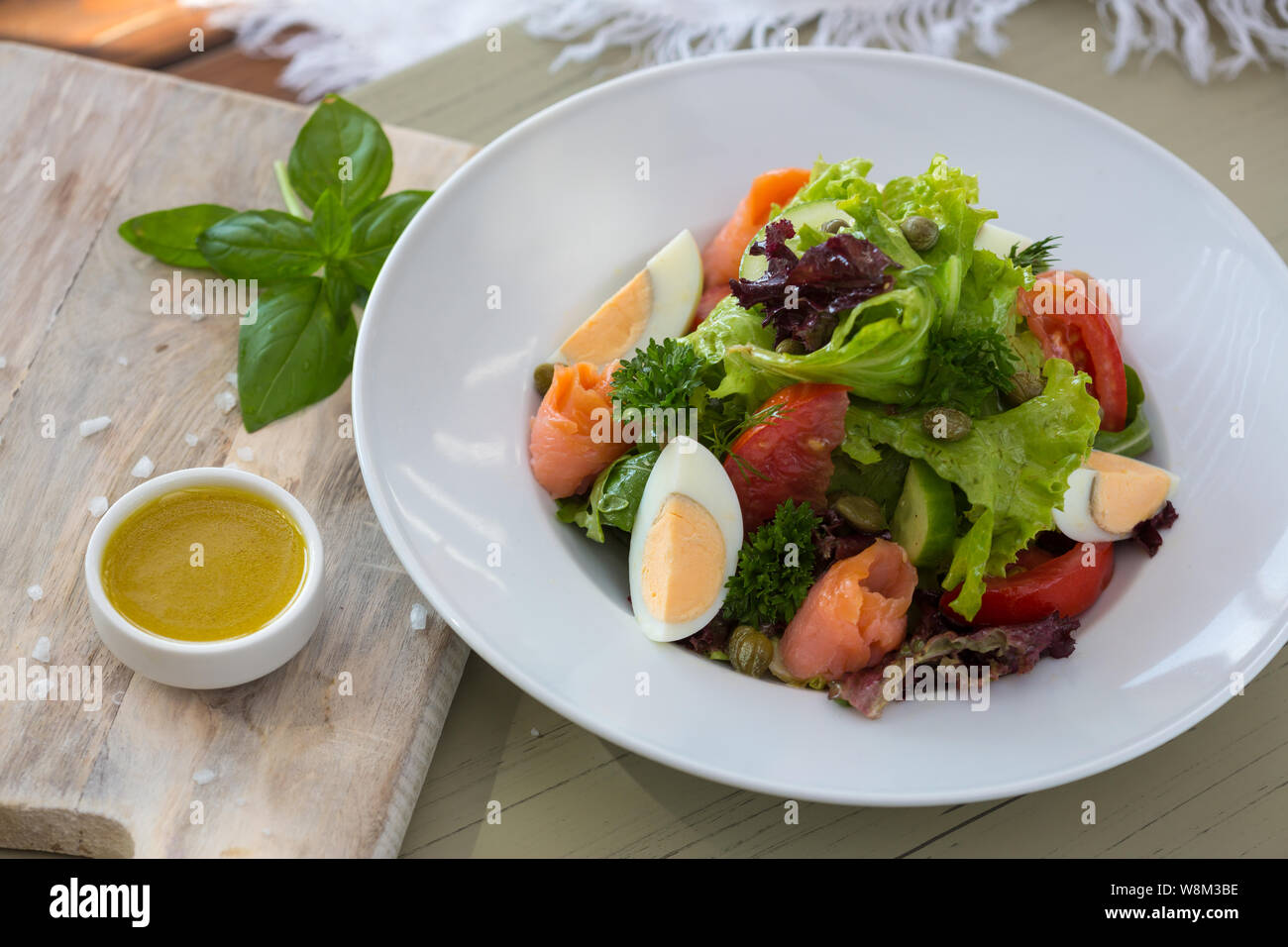Vegetable salad with egg and salmon served with basil and topping sauce Stock Photo