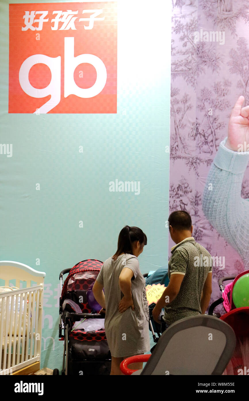 --FILE--A Chinese couple shops for a baby stroller at the stand of Chinese baby products maker Goodbaby (gb) during an expo in Fuzhou city, southeast Stock Photo
