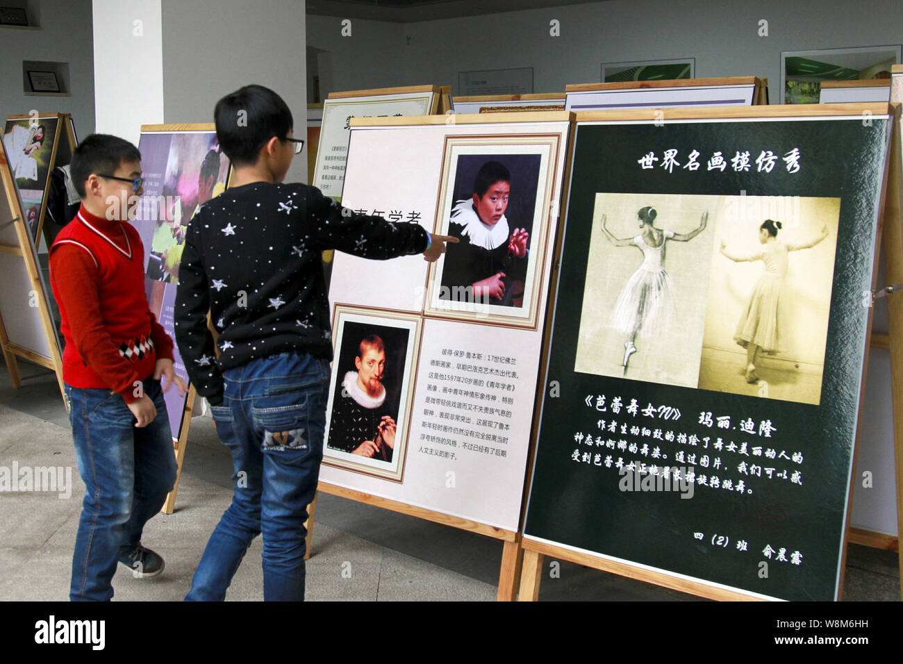 Chinese pupils look at placards showing creations by students replcating world's famous paintings during an art festival at Hangzhou Shengfulu Primary Stock Photo