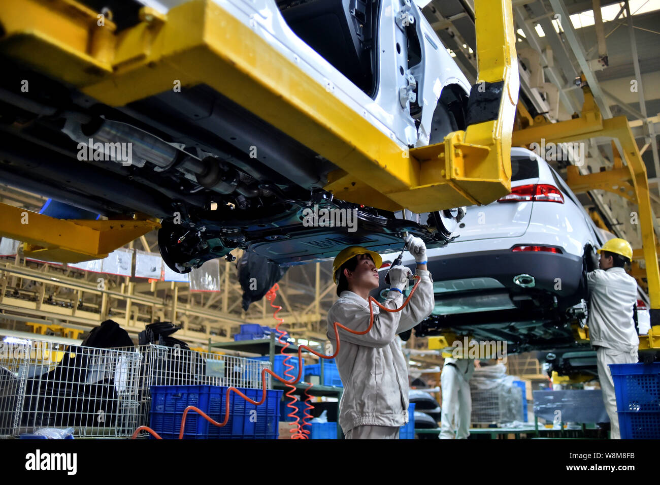 Chinese workers assemble cars on the assembly line at an auto plant in ...