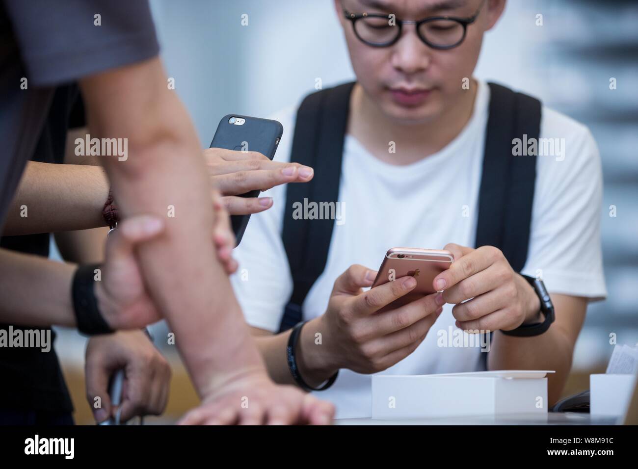--FILE--A Chinese customer tries out a rose gold iPhone 6s smartphone at the Apple Store near the West Lake in Hangzhou city, east China's Zhejiang pr Stock Photo