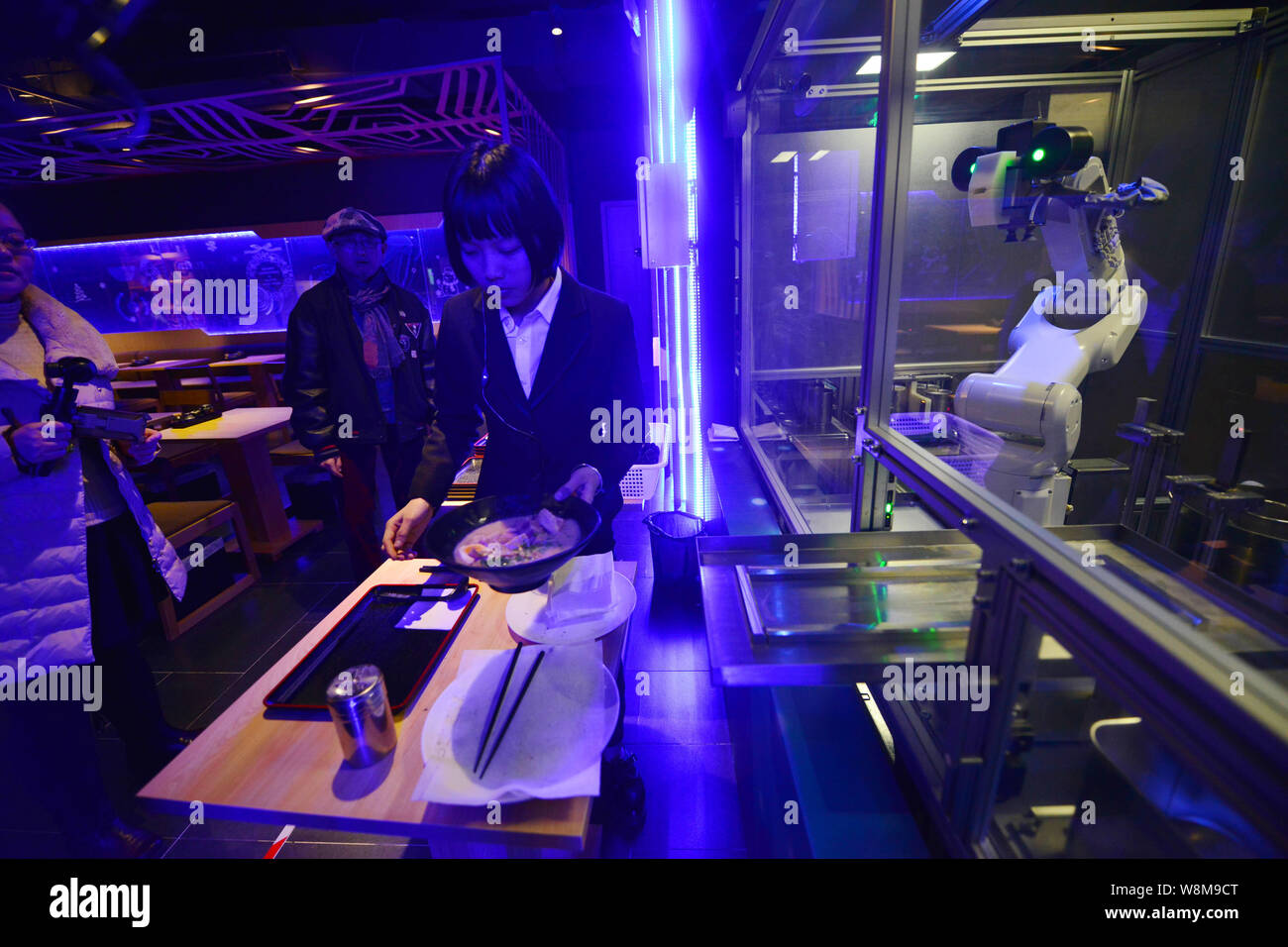 A waitress serves a bowl of noodles cooked by robots Koya and Kona at a