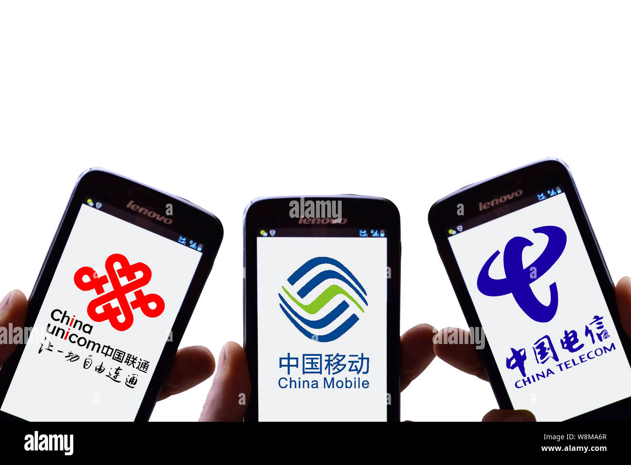 FILE--Chinese mobile phone users show logos of (from left) China Unicom,  China Mobile and China Telecom on their smartphones in Shaoyang city, centr  Stock Photo - Alamy