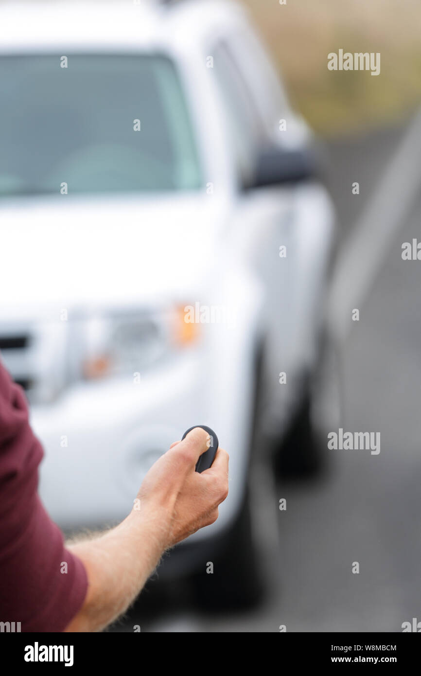 Person opening door starting car with remote key ignition starter. Car remote control key fob. Man driver unlocking car door with unlock keyless system. Car vacation rental or driver owning new car. Stock Photo