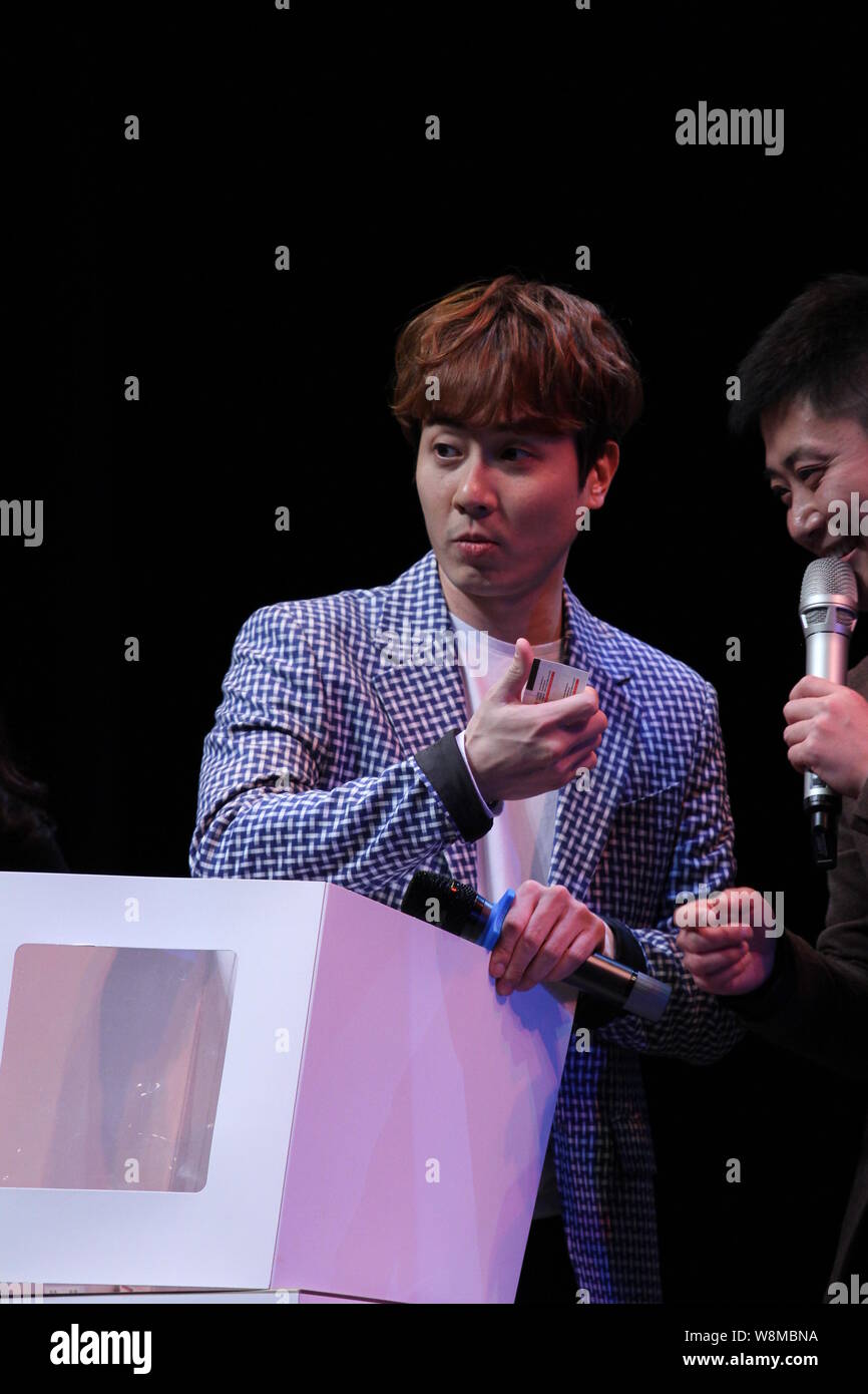 Andy Lee of South Korean pop group Shinhwa, left, reacts at his