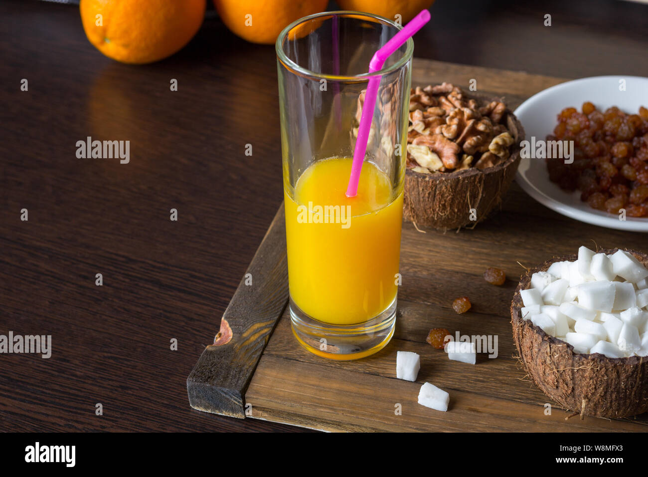 Tasty vegetarian breakfast on a wooden tray with copy space. Natural organic products for well-being. A glass of fresh orange juice with a straw. Coco Stock Photo