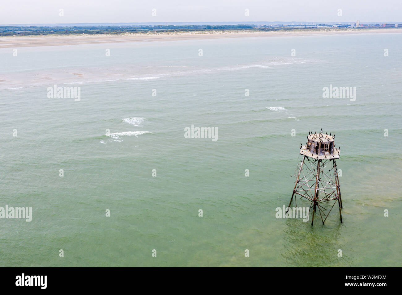 Historical lighthouse Walde tower full of birds, in Marck, near Calais, department of Pas-de-Calais, northern France, marks the border between North S Stock Photo