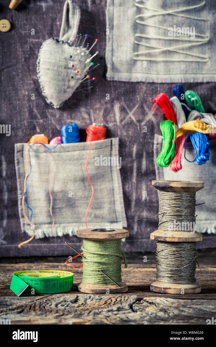Colored threads and needles in sewing workshop Stock Photo - Alamy