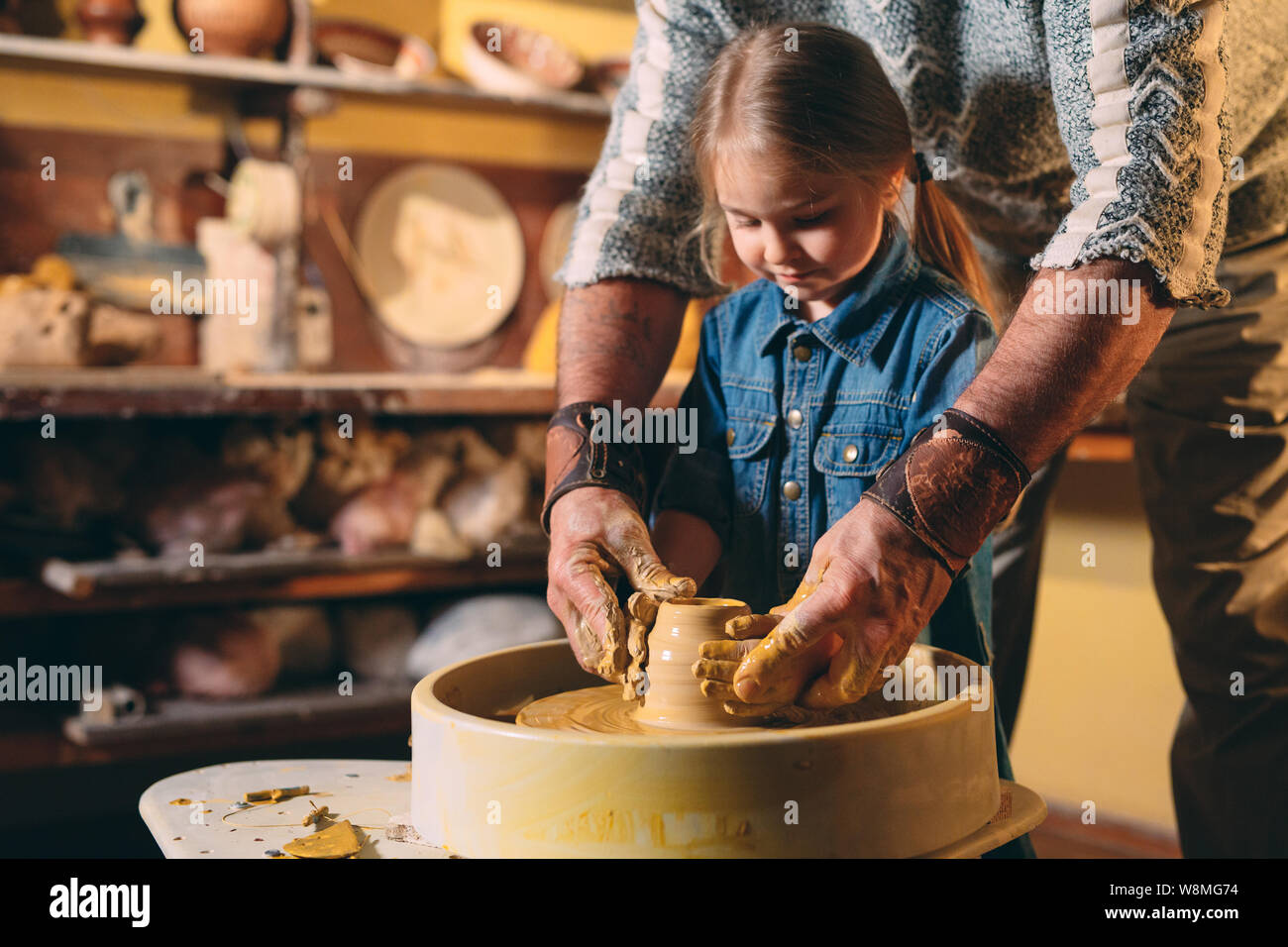 Pottery A little girl makes a vase of clay. Clay modeling