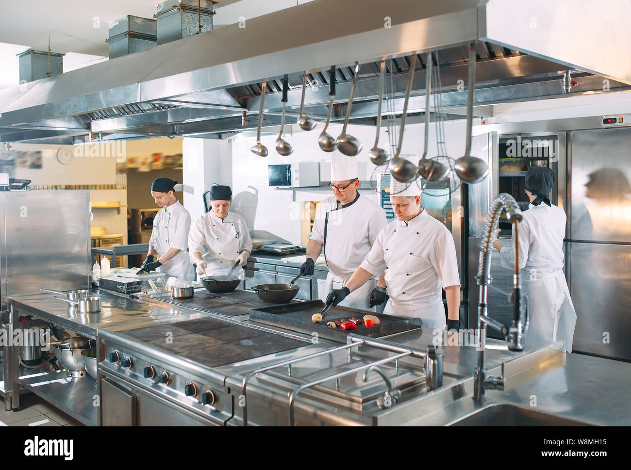 Five chefs wearing uniforms posing in a kitchen Stock Photo Alamy