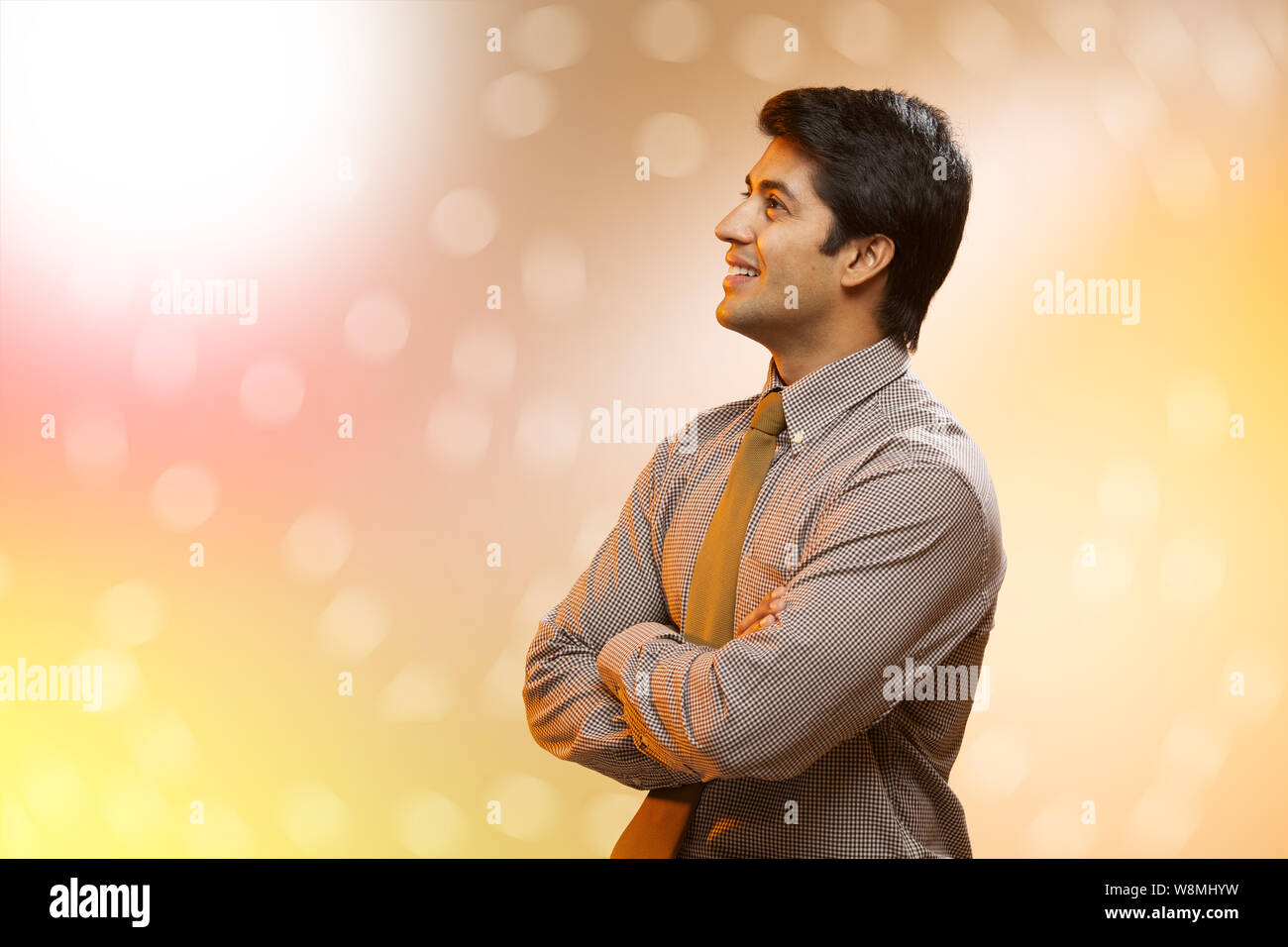 Businessman standing with his arms crossed and day dreaming Stock Photo