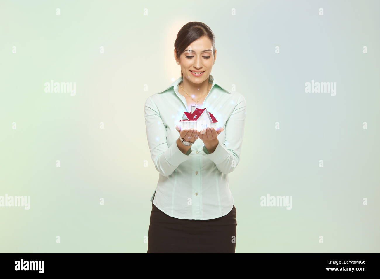 Real estate agent holding a model home Stock Photo Alamy