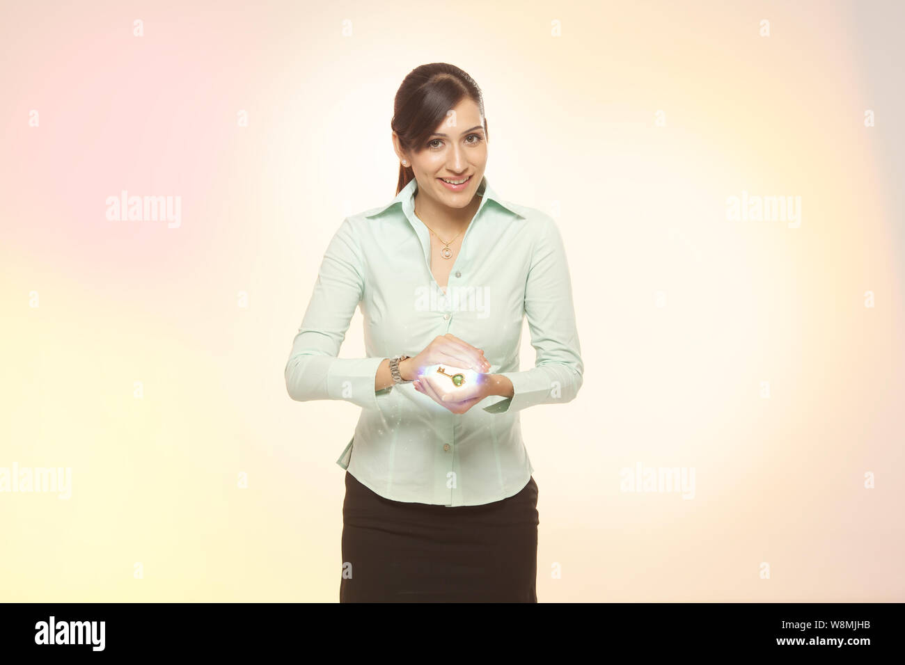 Businesswoman holding a glowing key Stock Photo