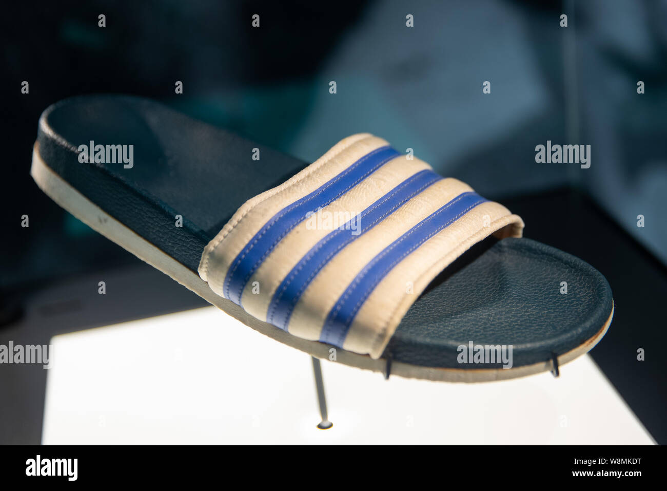 Herzogenaurach, Germany. 09th Aug, 2019. The shoe model "Adilette" from 1972  by the sporting goods manufacturer adidas is in a history exhibition about  the brand behind glass. Shortly before its 70th anniversary,