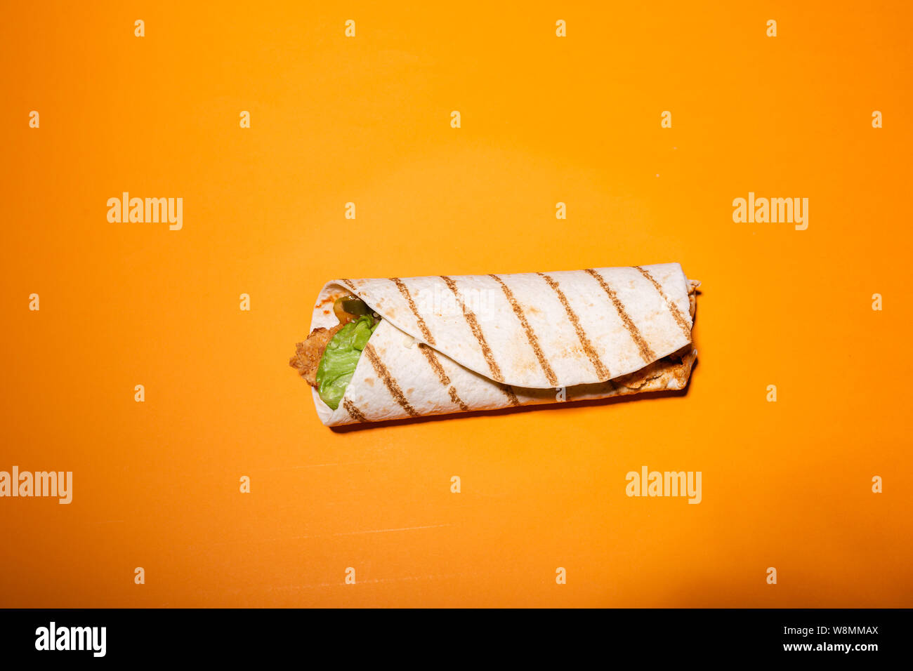 Flat lay photo of tortilla isolated on orange background Stock Photo