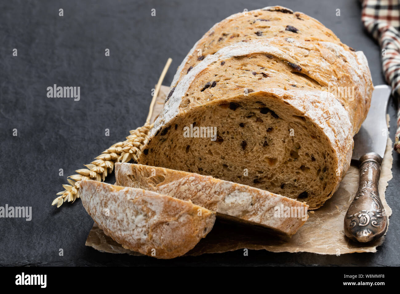 Homemade  black olive loaf bread on black stone table Stock Photo