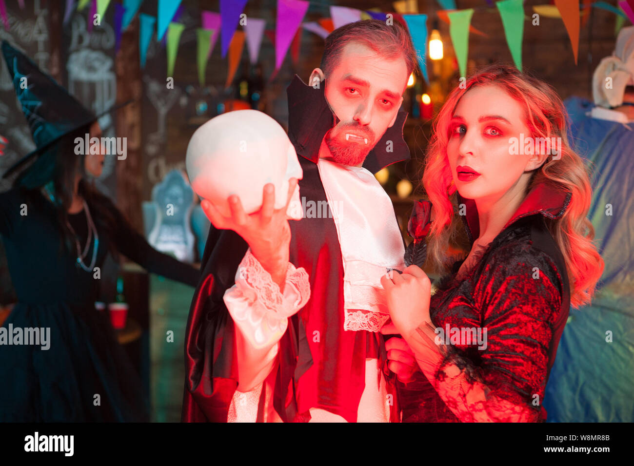 Attractive young couple dressed up like vampire costumes for halloween celebration. Halloween monsters gathering. Stock Photo