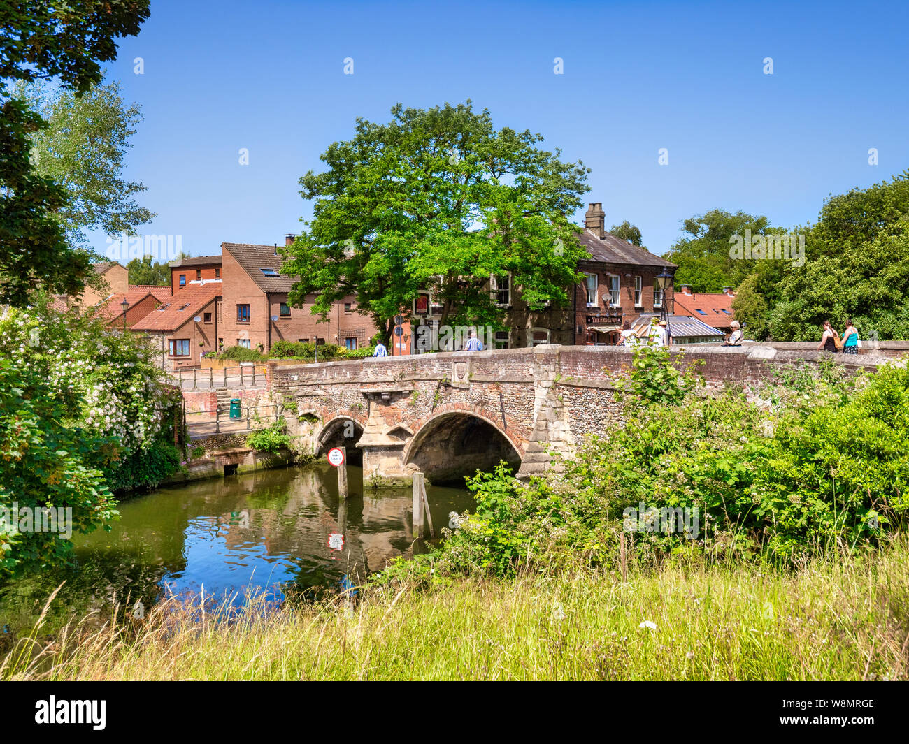 29 June 2019: Norwich, Norfolk, UK - Bishop Bridge, the original of which was built in 1340, spanning the River Wensum, on a fine summer day, clear bl Stock Photo