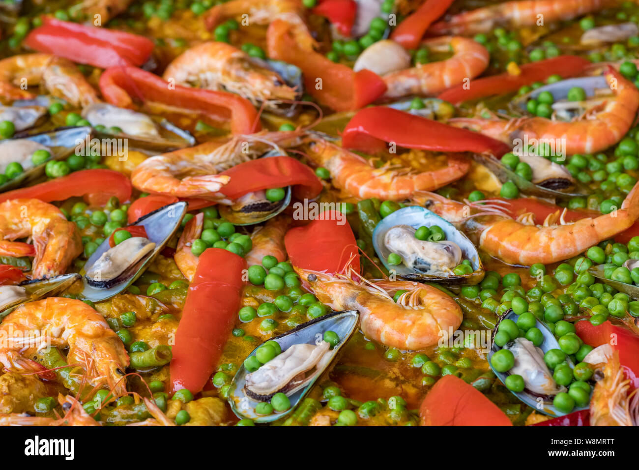 Spanish seafood paella in fry pan with mussels, shrimps and vegetables. Seafood paella background close up Stock Photo