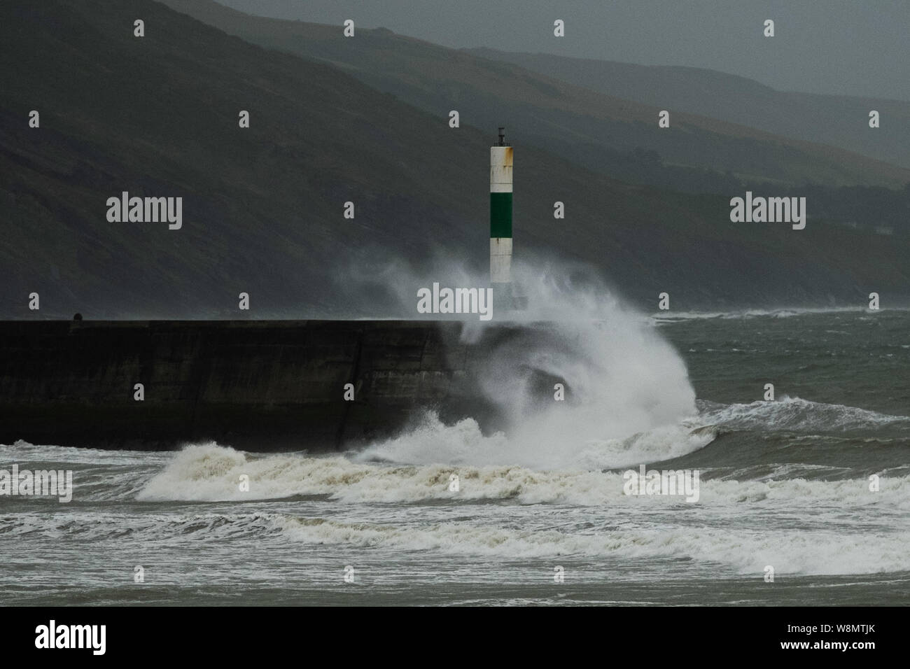 Aberystwyth, UK. 10th Aug, 2019. UK Weather: Gales force winds and stormy seas batter the harbour and lighthouse in Aberystwyth as unseasonably wet and windy weather sweeps across much of the west of the UK , bringing severe disruption to travel and forcing the cancellation of many outdoor events. Credit: keith morris/Alamy Live News Stock Photo