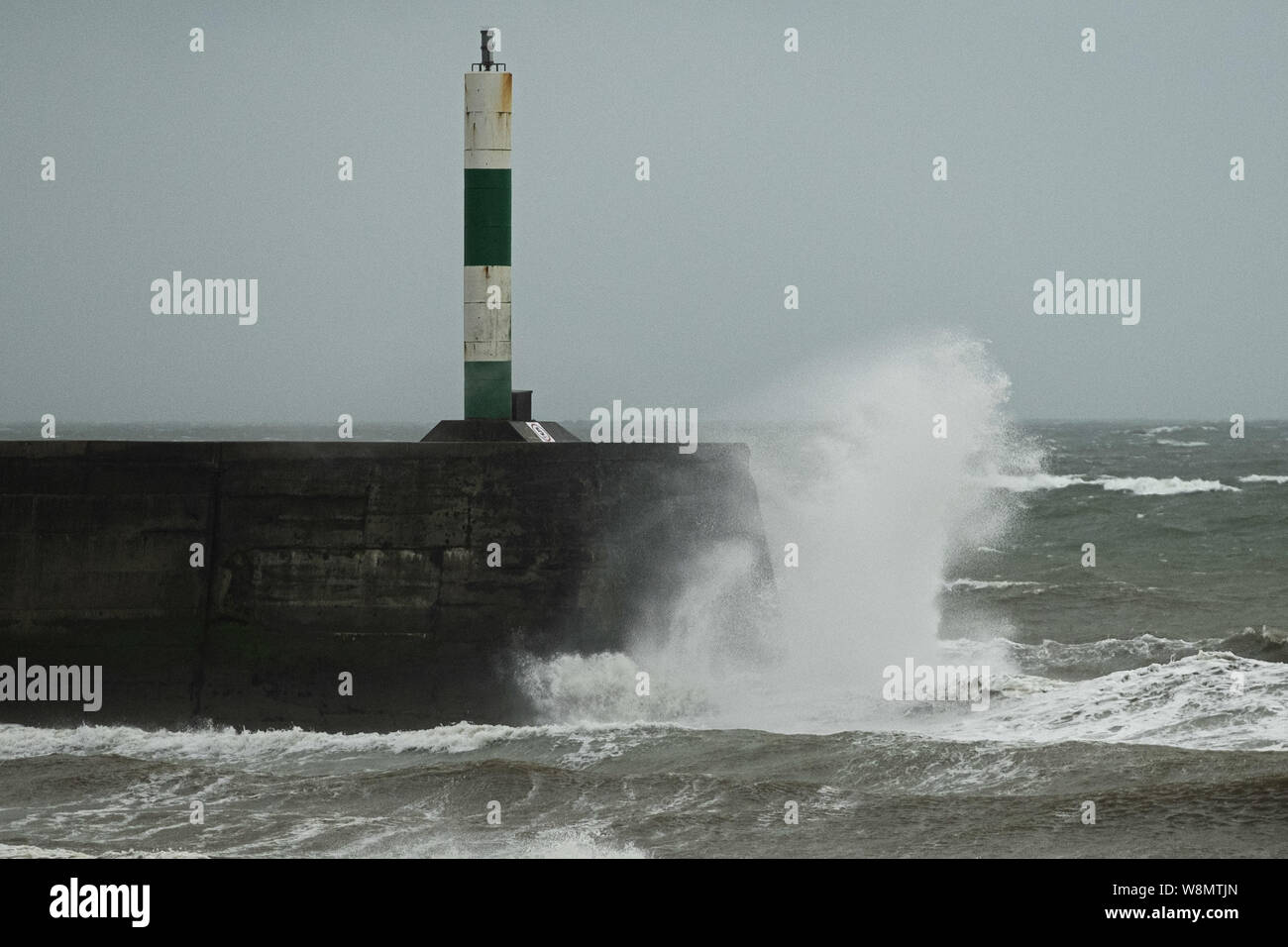 Aberystwyth, UK. 10th Aug, 2019. UK Weather: Gales force winds and stormy seas batter the harbour and lighthouse in Aberystwyth as unseasonably wet and windy weather sweeps across much of the west of the UK , bringing severe disruption to travel and forcing the cancellation of many outdoor events. Credit: keith morris/Alamy Live News Stock Photo