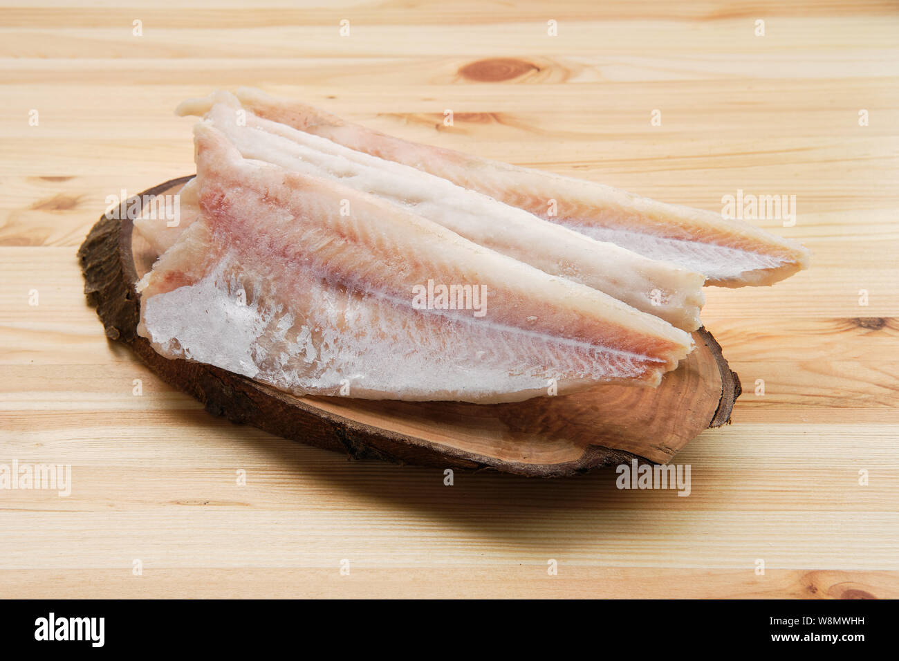 Frozen fillet of pangasius on wooden table Stock Photo