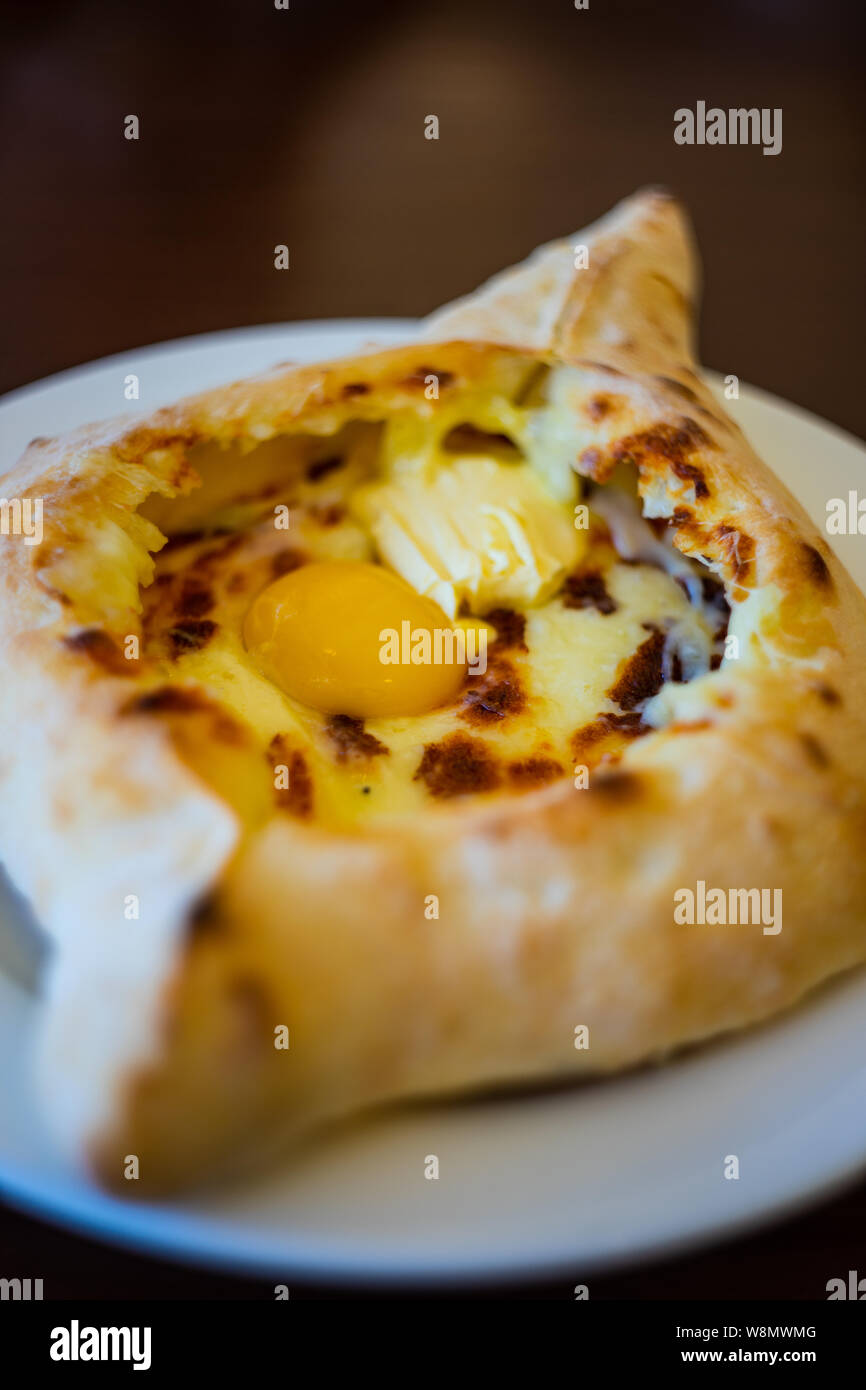 Traditional georgian khachapuri with eggs and cheese in boat shaped bread known as a Adjarian khachapuri Stock Photo