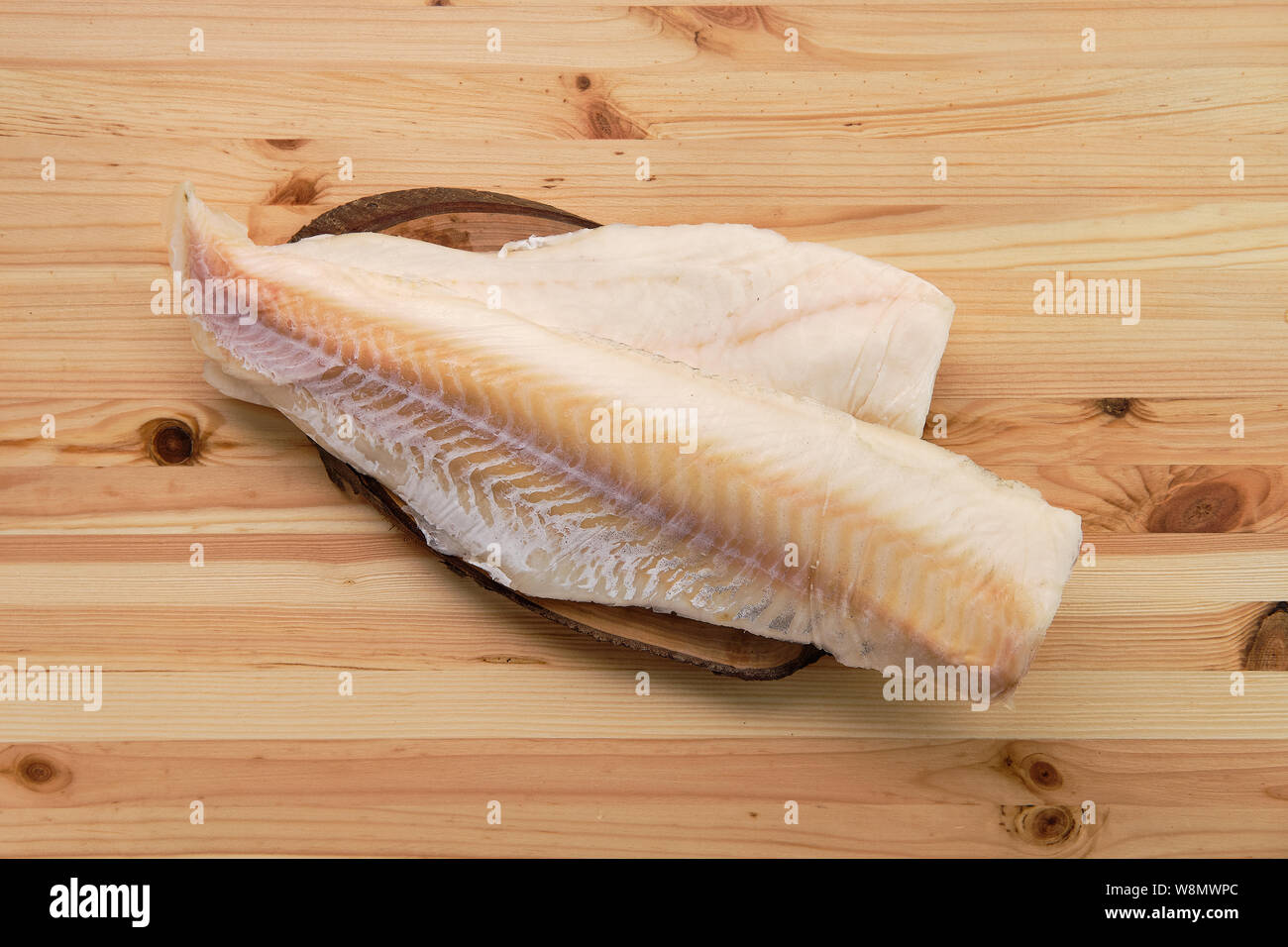 Frozen fillet of cod on wooden table Stock Photo
