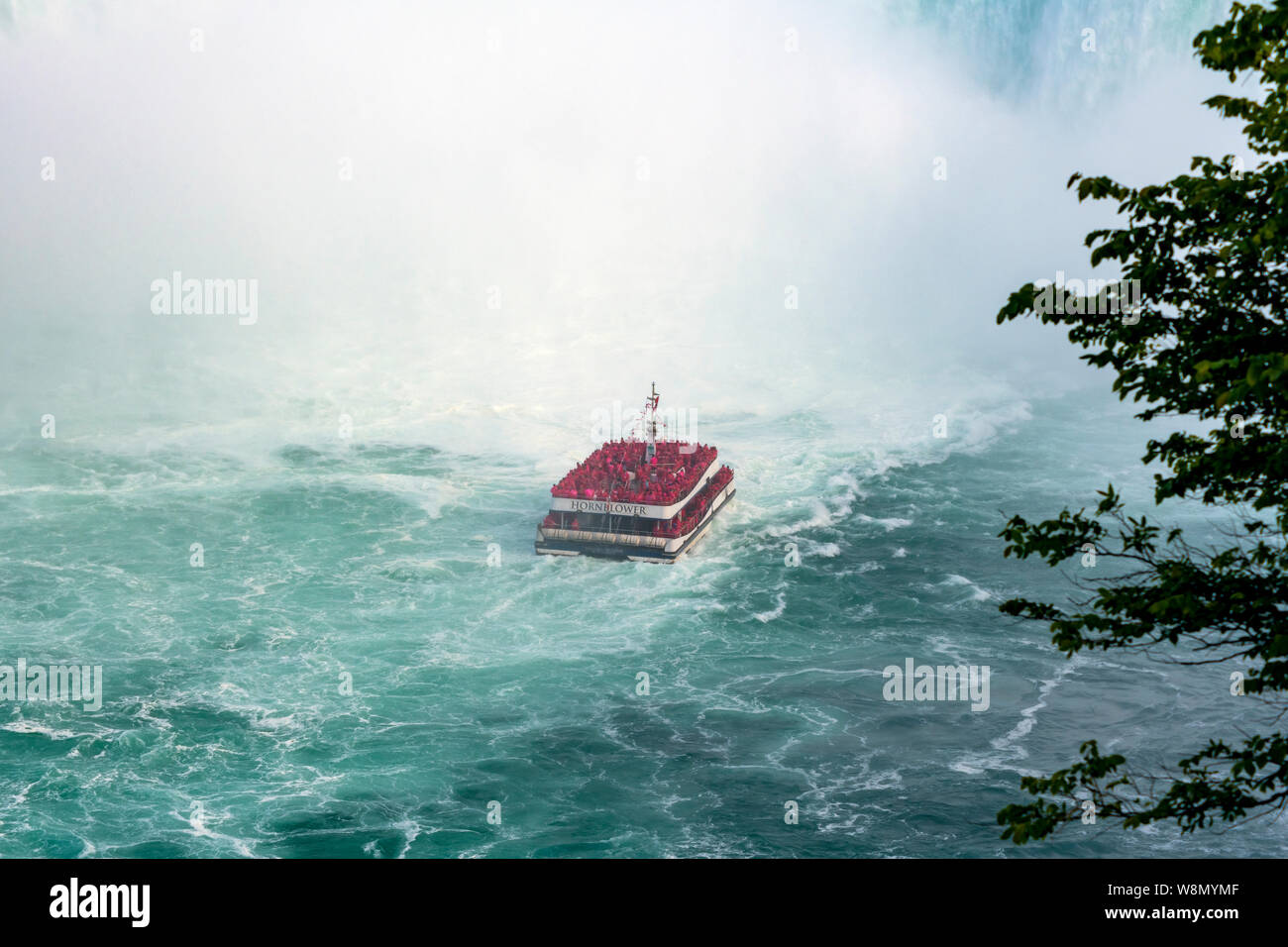 Boat carrying tourists at the bottom of Niagara Falls Stock Photo