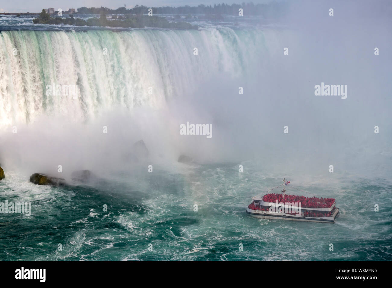 Boat carrying tourists at the bottom of Niagara Falls Stock Photo