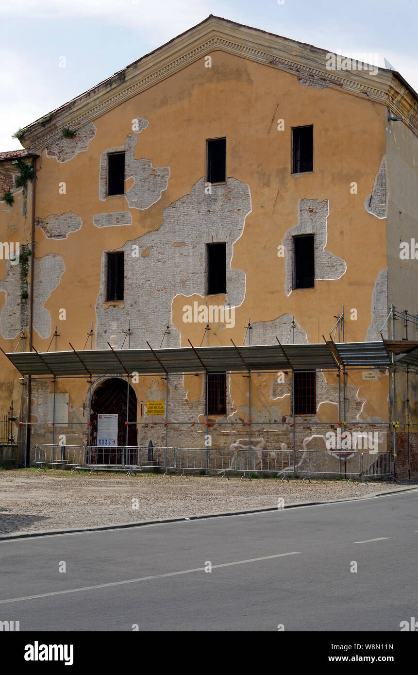 An apparently abandoned building in Mantua, Italy, with spalling render, which has been trimmed to leave curvaceous shapes like an abstract painting Stock Photo