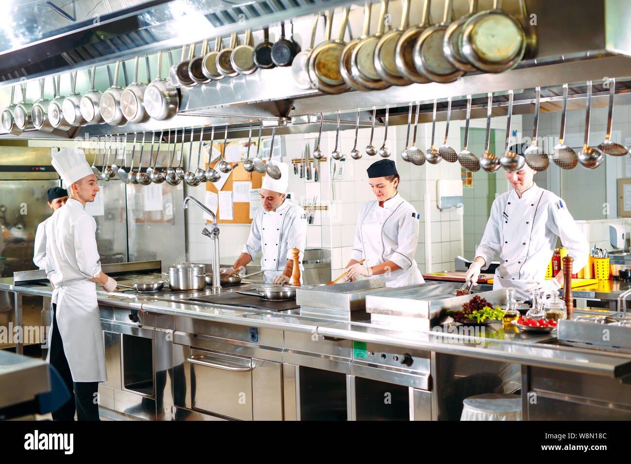 Modern kitchen. Cooks prepare meals on the stove in the kitchen of the ...