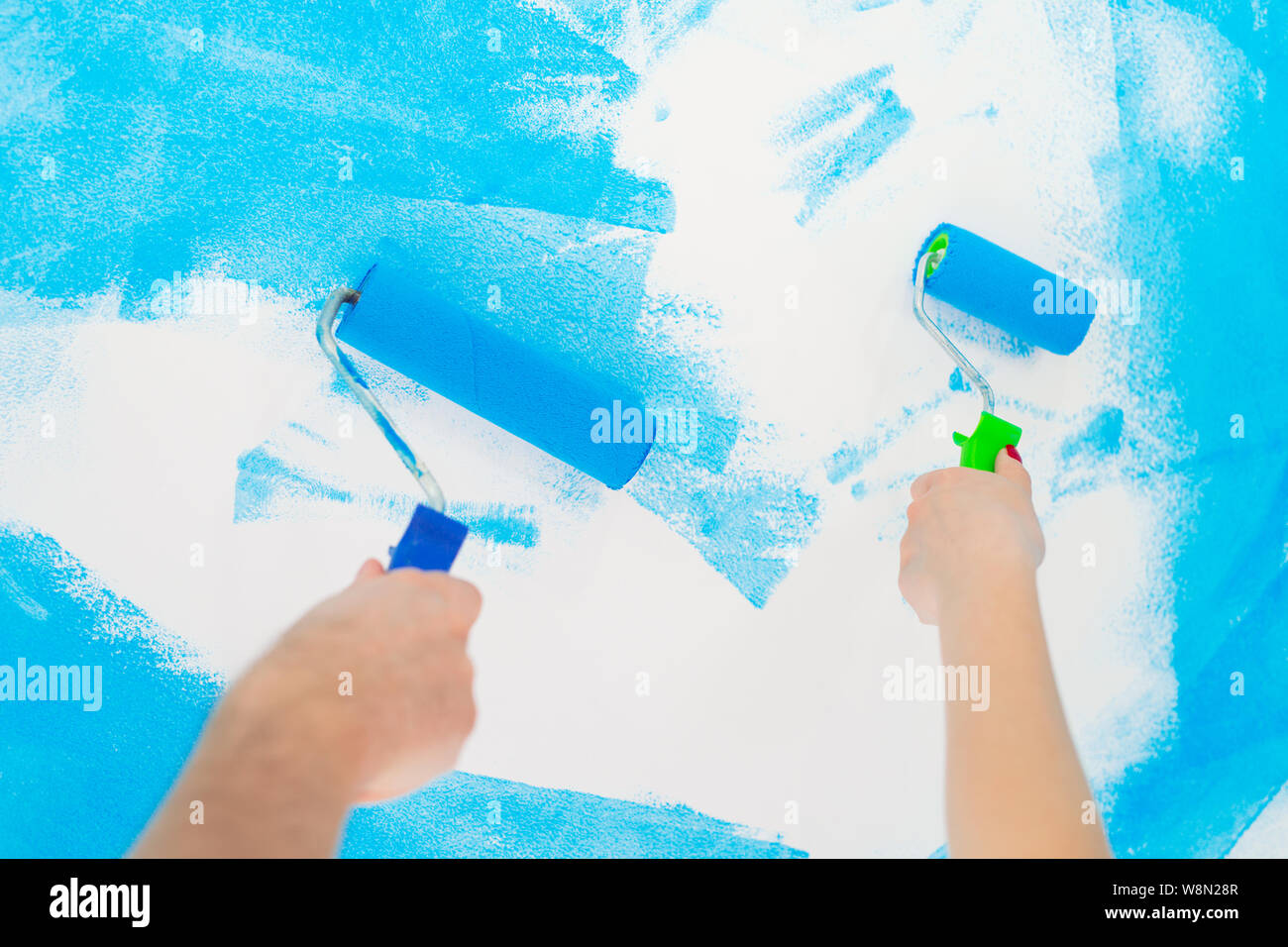 blue color painting wall with roller in hand Stock Photo - Alamy