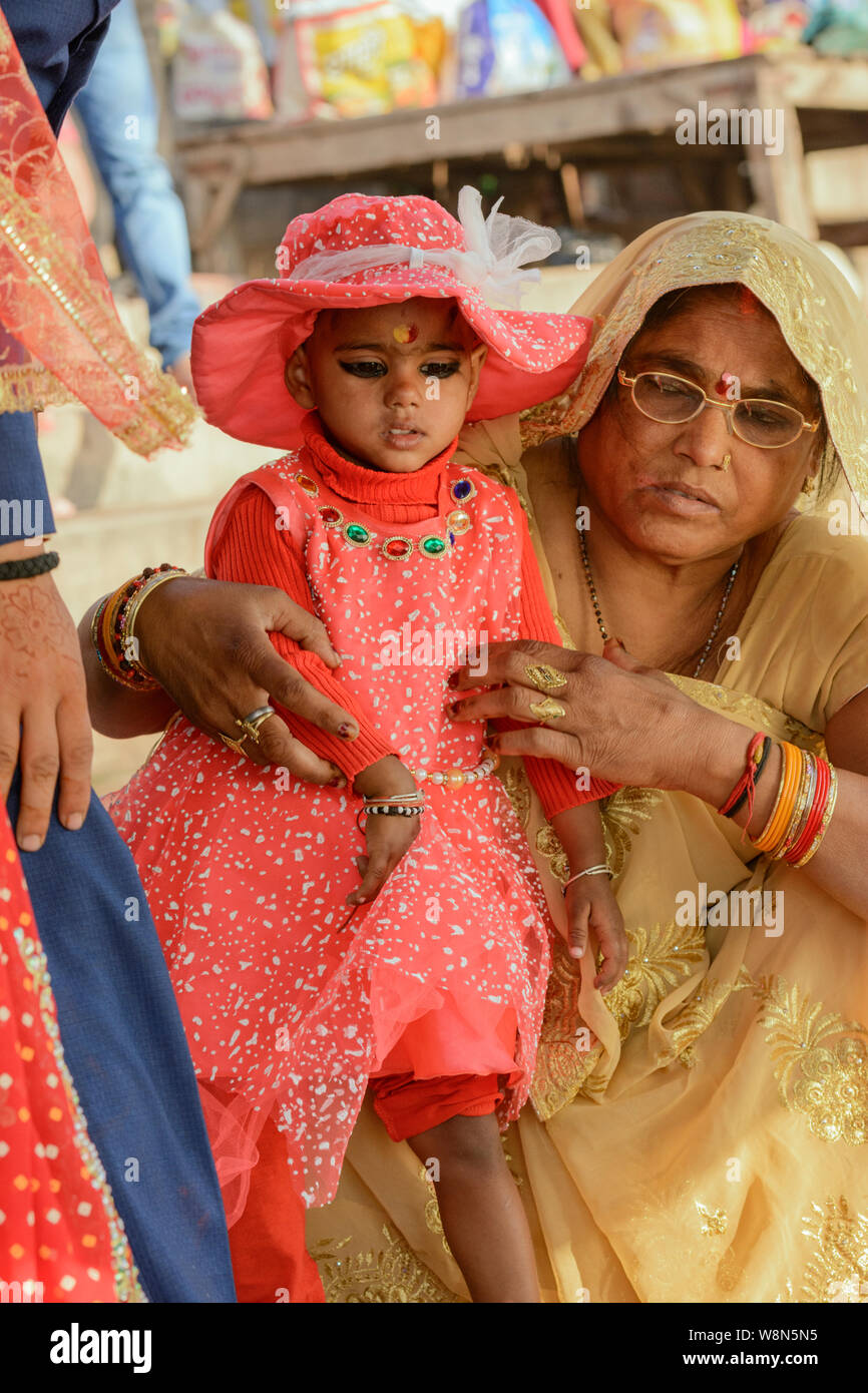 A young girl and grandmother attend a traditional Indian Hindu wedding on the banks of the River Ganges in Varanasi, Uttar Pradesh, India, South Asia Stock Photo