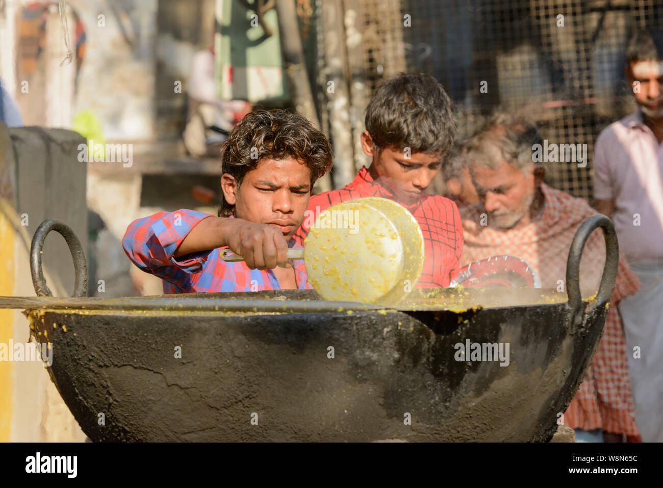 Young Indian boys prepare food for pilgrims in Varanasi, Uttar Pradesh, India, South Asia. Also known as Benares, Banaras and Kashi. Stock Photo