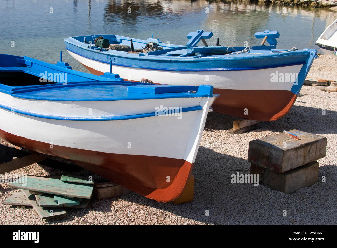 Blue white and red painted wooden boats on the beach in village