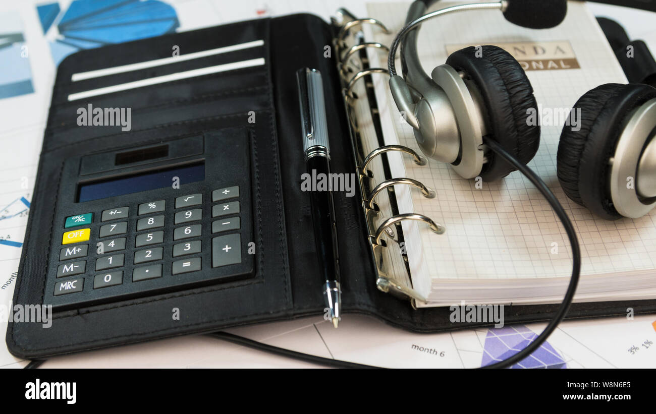 Close-up, headset lying on an organizer notepad. Call center table. Stock Photo