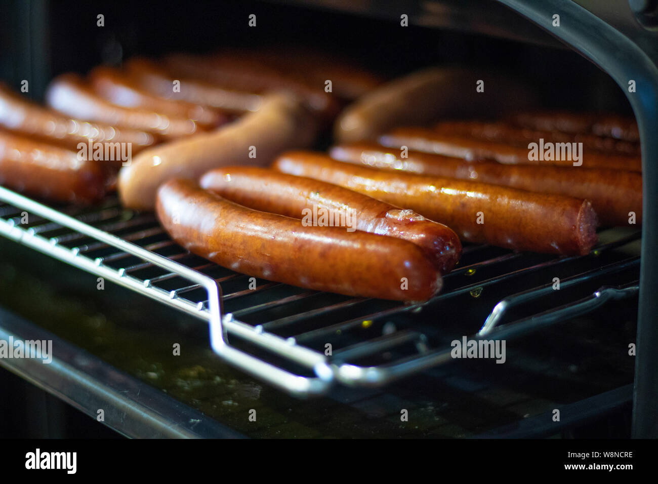 Cooking sausages in the oven. Fast food street. Fried sausages Stock Photo