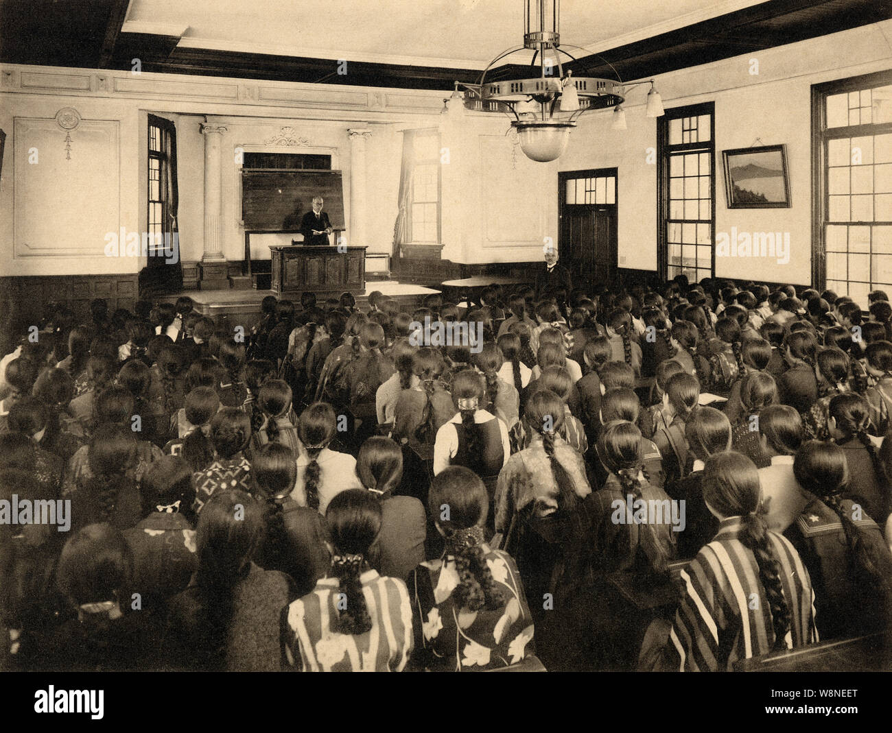 [ 1920s Japan - Japanese Girl’s High School ] —   Lecture at Miwada Girl’s High School (三輪田高等女學校) in Kudan-kita, Tokyo, 1928 (Showa 3). The school still exists and is now known as Miwada Gakuen (三輪田学園中学校).  The school was founded in Matsuyama, Shikoku, in 1880 (Meiji 13) by female educator Masako Miwada (1843-1927, 三輪田眞佐子), but moved to Tokyo in (1887 (Meiji 20). A scholar of the Chinese classics (漢学者), Miwada was among the first to promote education for girls.  20th century vintage gelatin silver print. Stock Photo