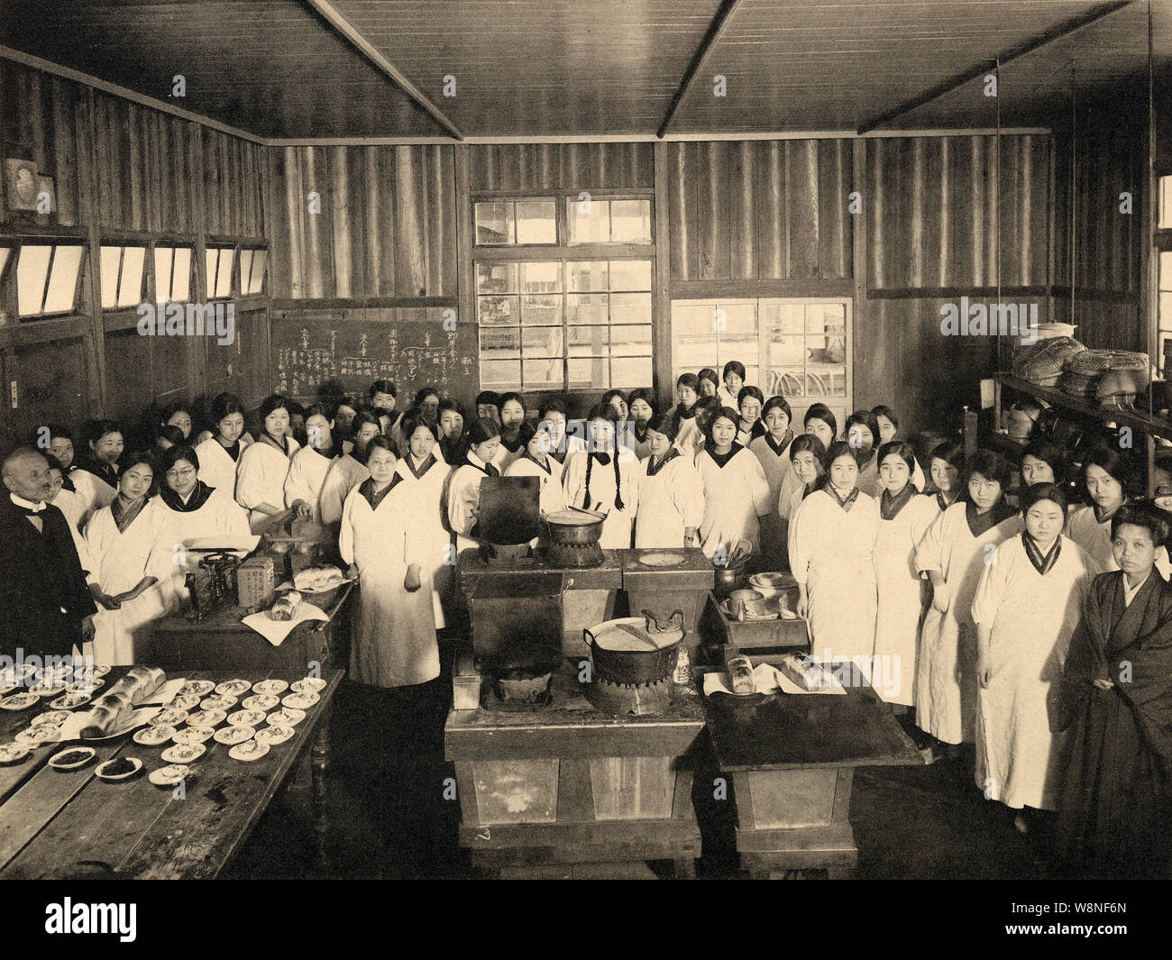 [ 1920s Japan - Japanese Girl’s High School ] —   Cooking class at Miwada Girl’s High School (三輪田高等女學校) in Kudan-kita, Tokyo, 1928 (Showa 3). The school still exists and is now known as Miwada Gakuen (三輪田学園中学校).  The school was founded in Matsuyama, Shikoku, in 1880 (Meiji 13) by female educator Masako Miwada (1843-1927, 三輪田眞佐子), but moved to Tokyo in (1887 (Meiji 20). A scholar of the Chinese classics (漢学者), Miwada was among the first to promote education for girls.  20th century vintage gelatin silver print. Stock Photo