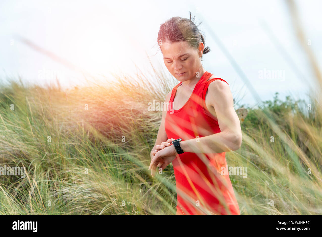 woman jogger checking her smart watch, heart rate, calories, number of steps Stock Photo