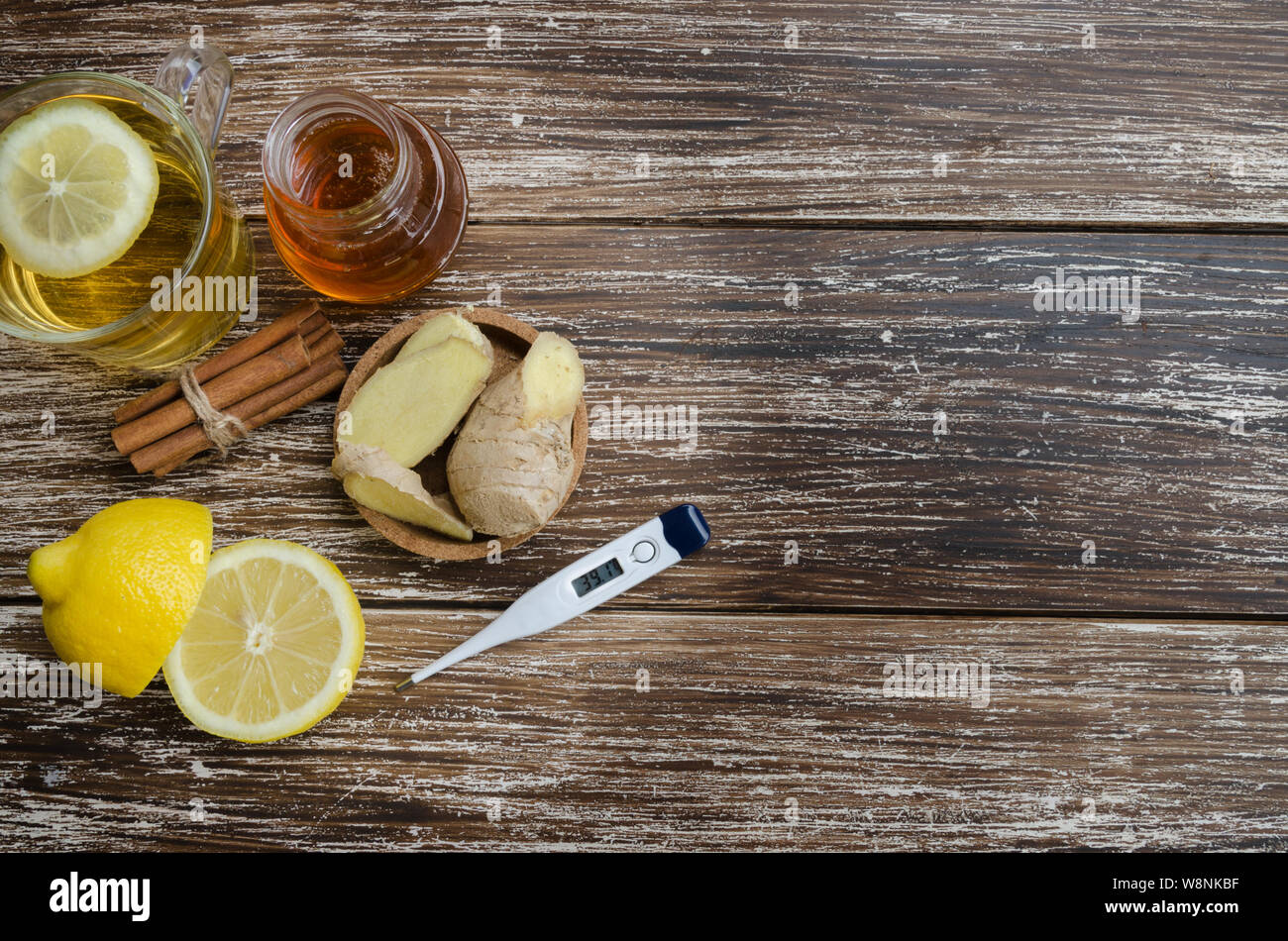 Ginger , lemon,spice honey and with thermometer.  Alternative treatment for cold or flu symptoms. Traditional medicine and natural health care concept Stock Photo