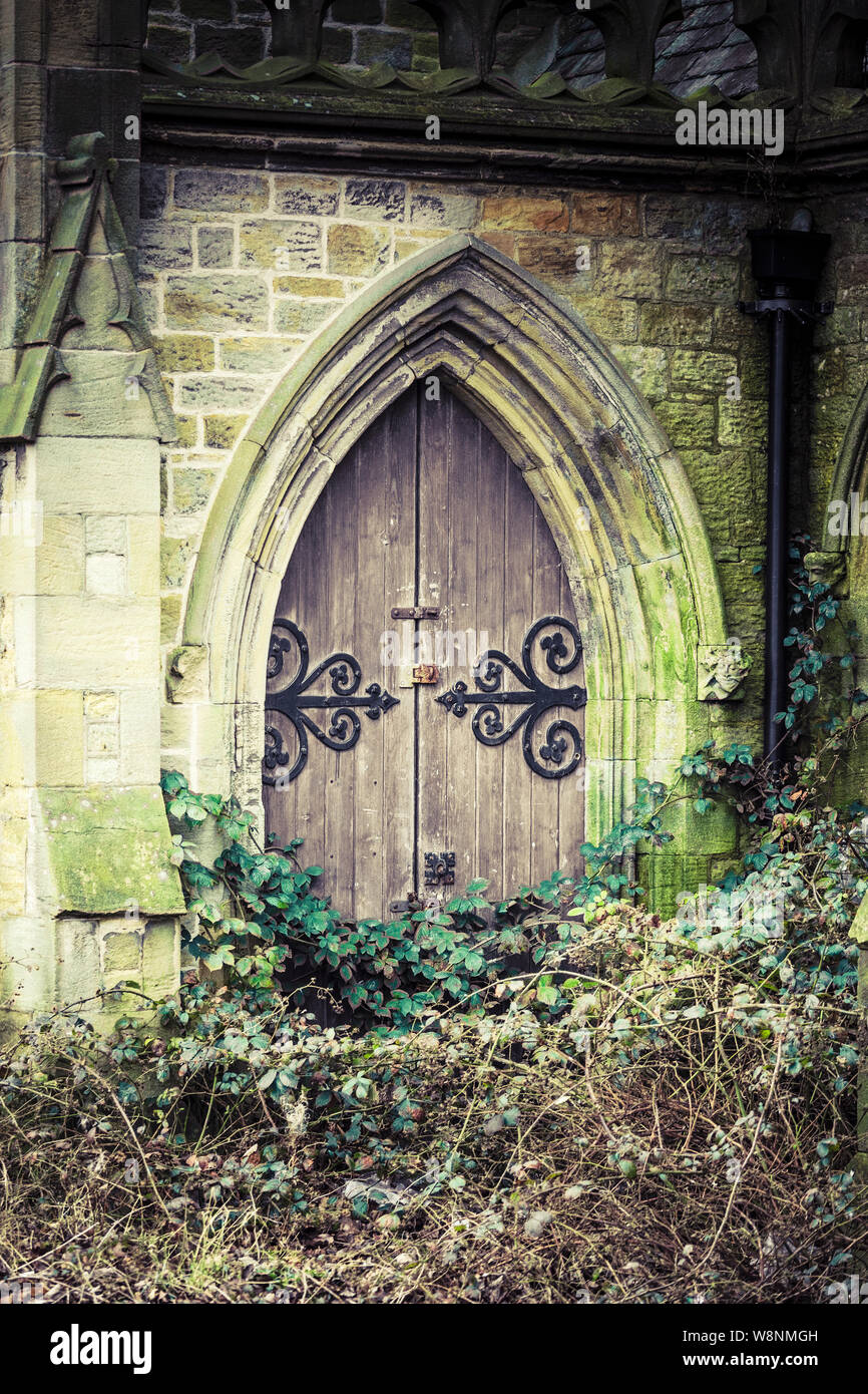 Overgrown and derelict church or chapel of rest door in a cemetery in Newcastle upon Tyne, Tyne