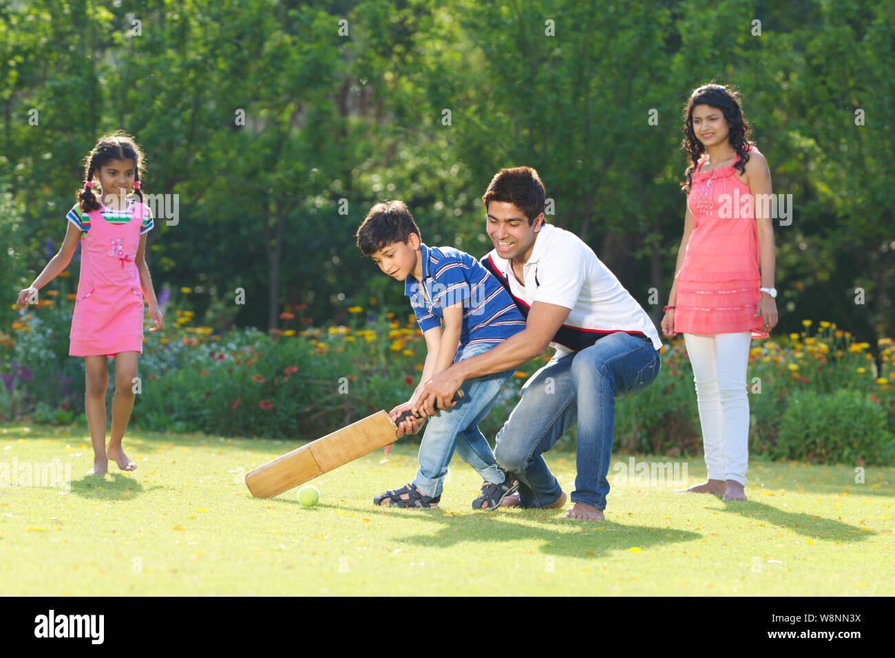 Family playing cricket in a garden Stock Photo Alamy