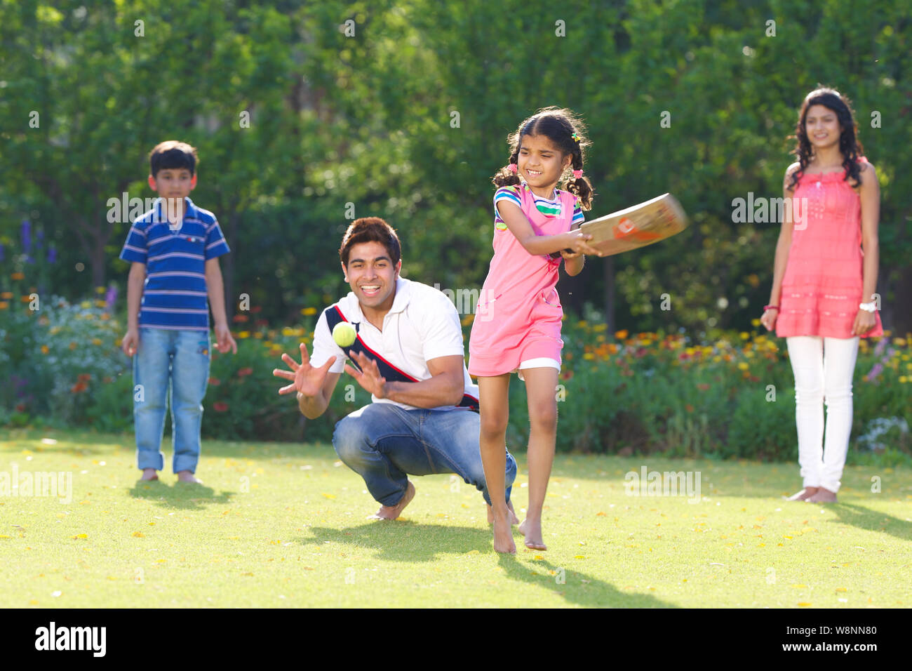 Family playing cricket in a garden Stock Photo Alamy